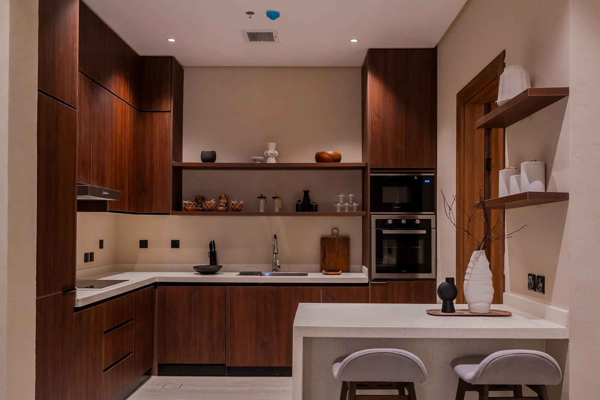 Photograph of a kitchen at Al Majdiah 163 with dark timber cabinets