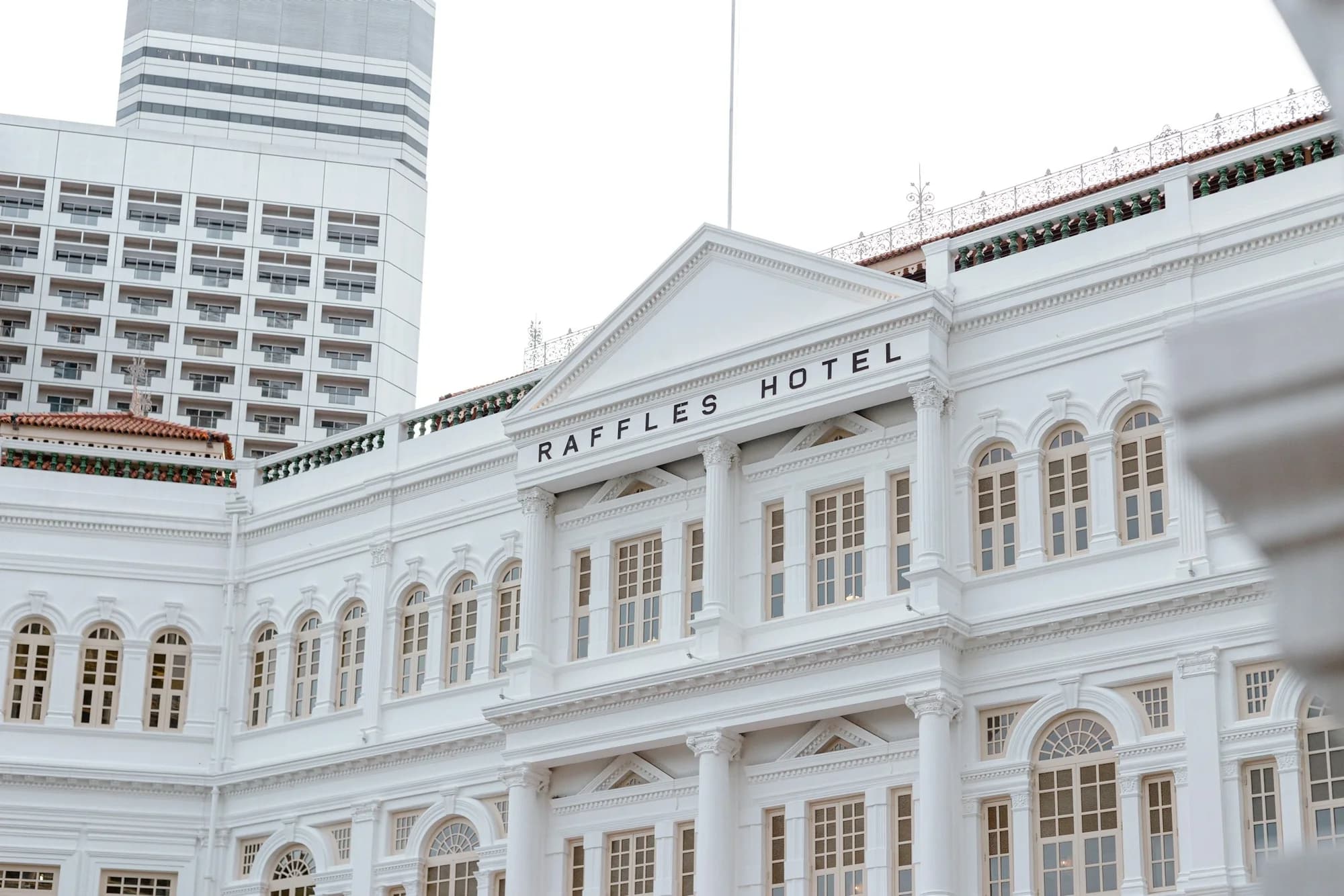 The white façade, windows and pediment of Raffles Hotel Singapore.