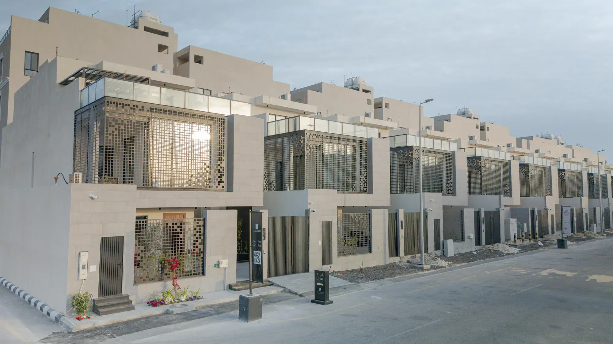 Photograph of a row of completed villas with glass and stone facades in Al Bahr, Al Khobar
