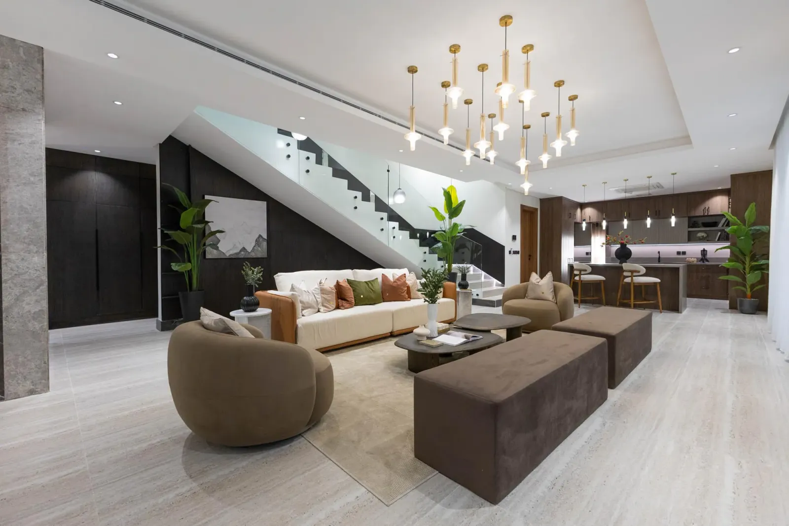 Photograph of a villa living room at Al Majdiah 158 with a staircase and a chandelier