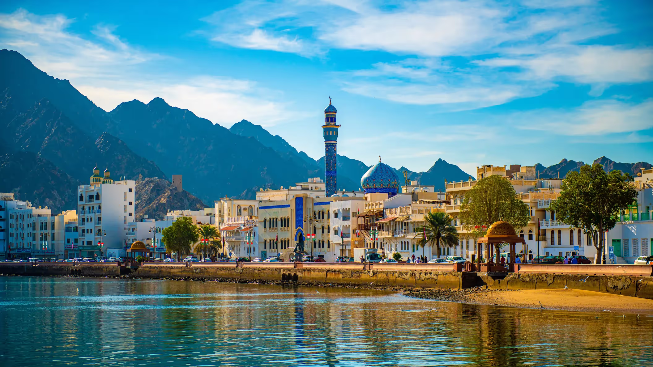 Muscat waterfront at Al Mouj: marina, low-rise residences and the Al Hajar mountains beyond